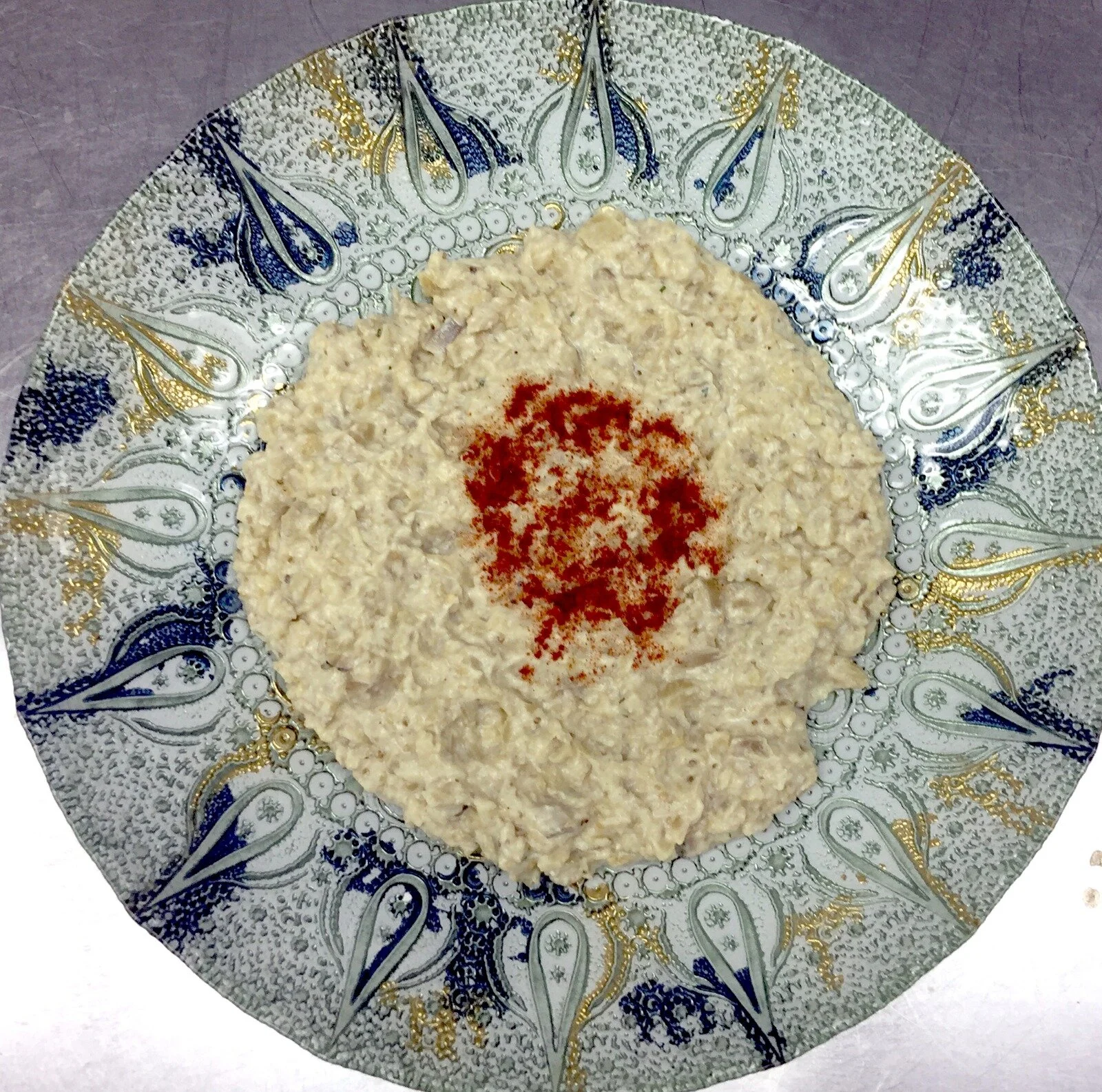 Hummus on hand-painted ceramic — chickpea, tahini, paprika
