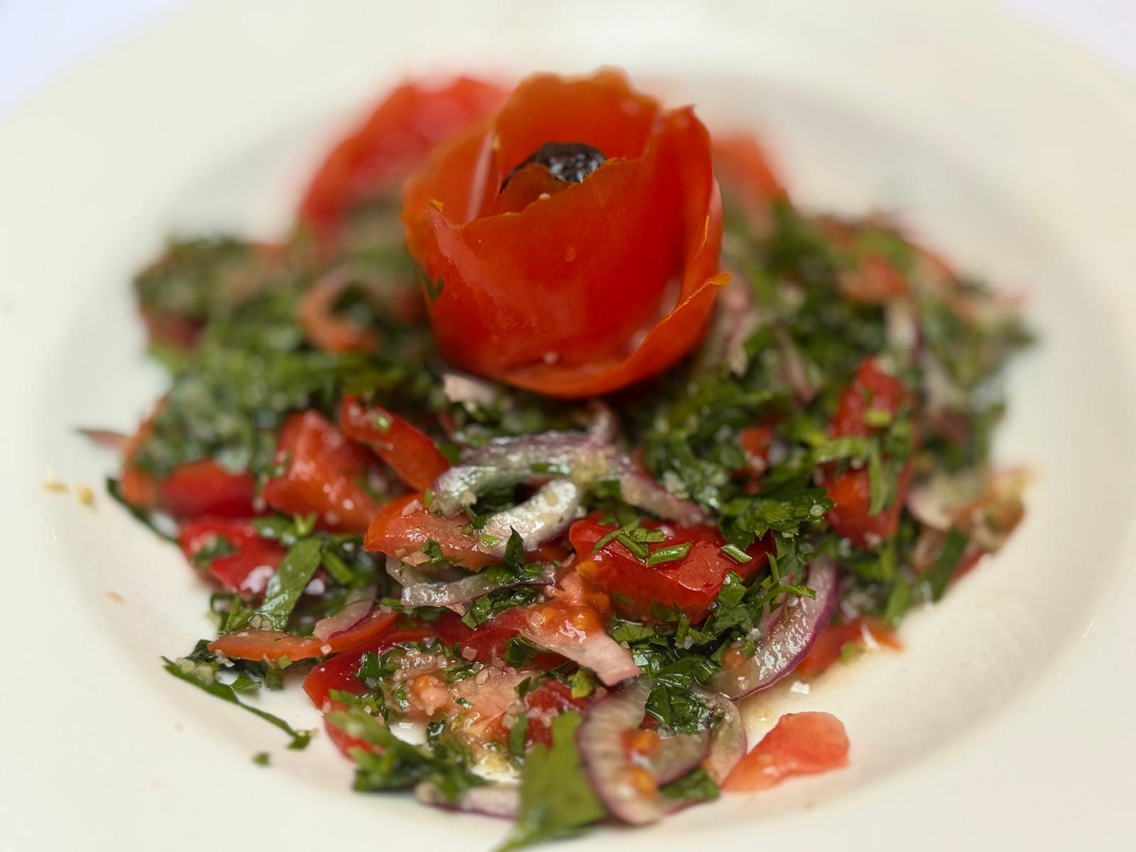 Tomato salad with red onion, parsley, and tomato rose